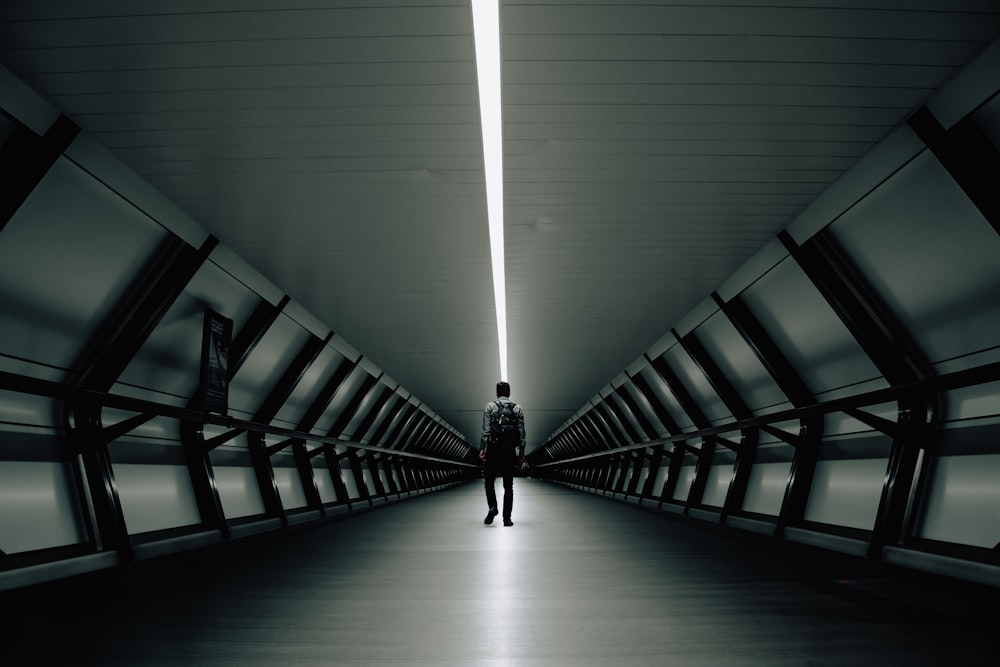 man walking inside tunnel