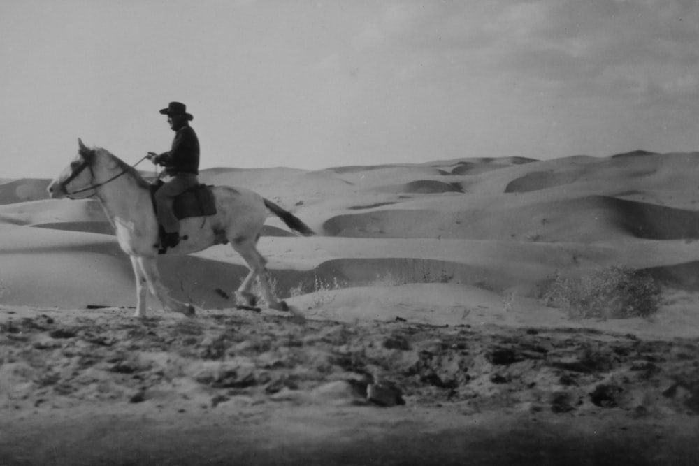 man riding horse on desert