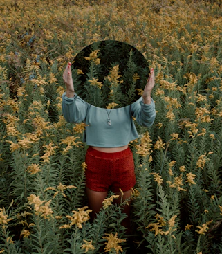 standing woman surrounded by yellow flower field during daytime