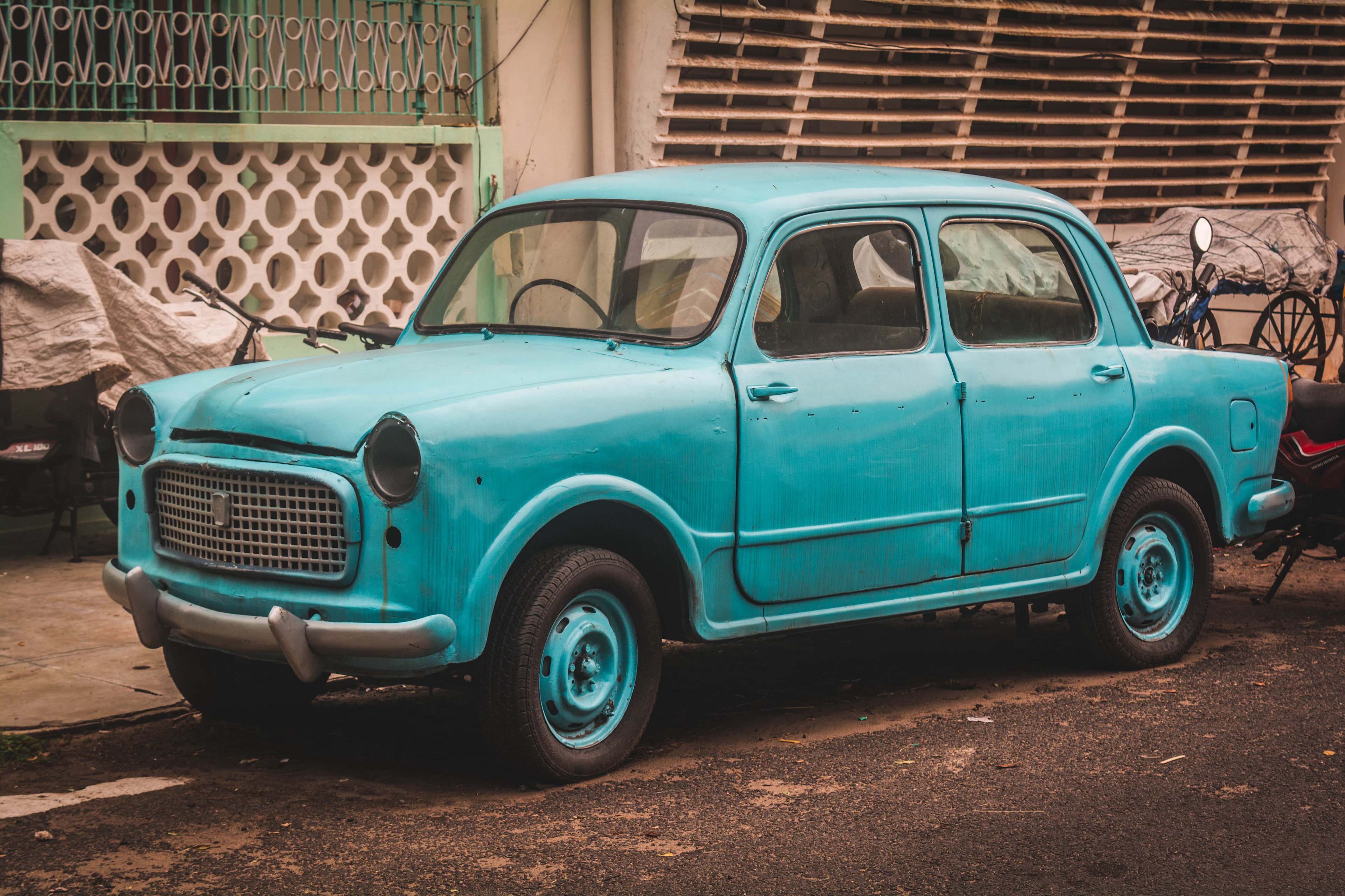A teal vintage sedan seen from the front left