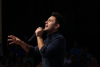 man singing in front of audience