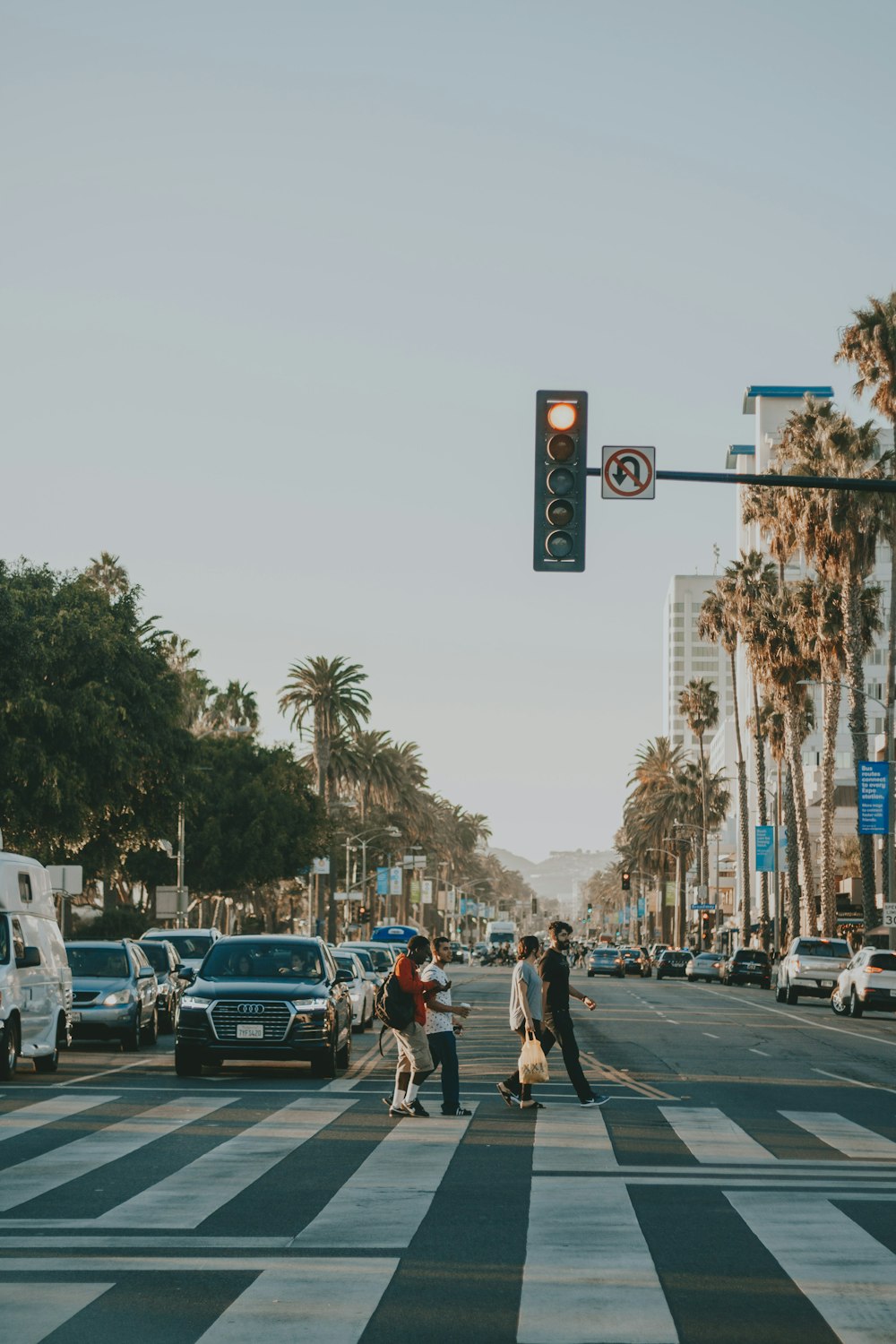 four person walking across the street under traffic light