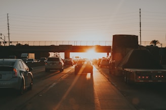 A busy highway with trucks moving efficiently toward their destinations at sunset.