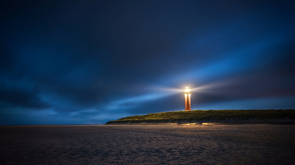 phare sous ciel nuageux pendant la nuit