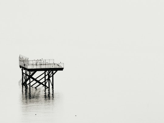 grayscale photography of tower above calm body of water in Meersburg Germany