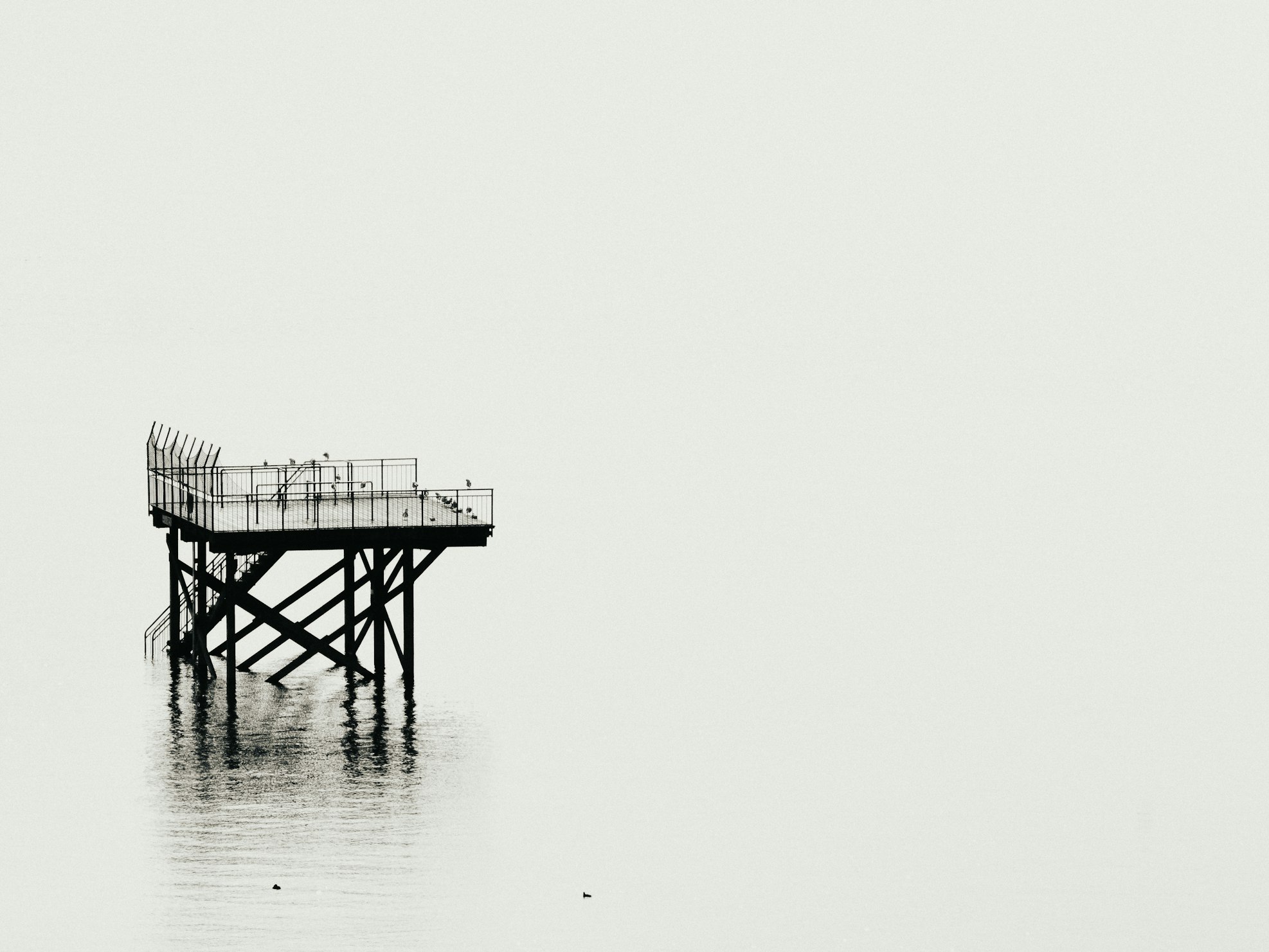 Silhouette of Dock against white sea background