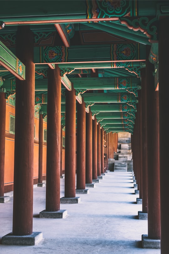 brown wooden post temple with green roof photo during daytime in Gyeonghuigung South Korea