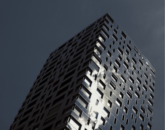 A striking close-up of a glass and steel facade reflecting a moody London sky.