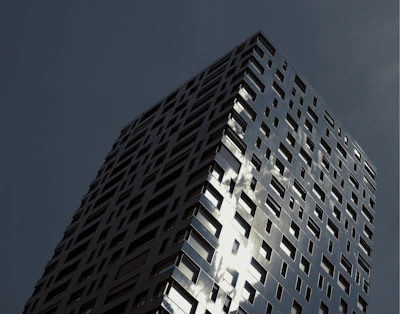 Modern high-rise glass building reflecting the sky.