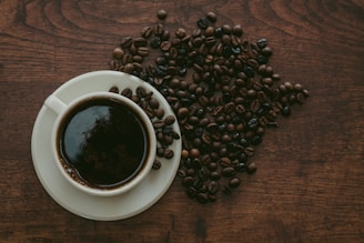 cup of coffee surrounded by beans