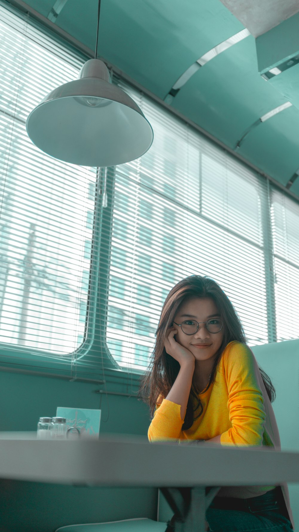 woman in yellow sweatshirt infront of table