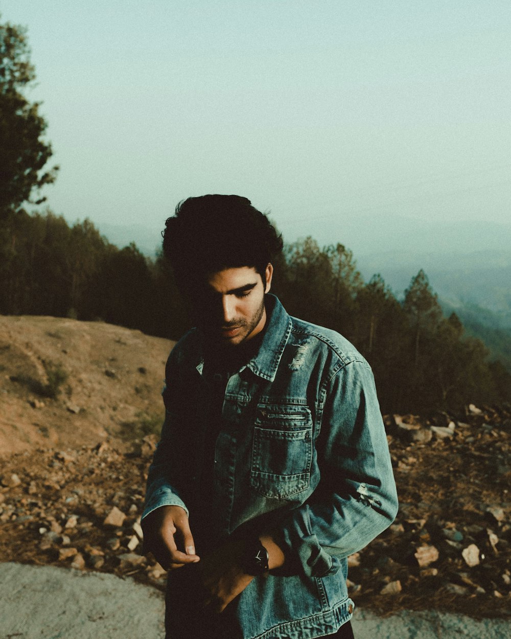 man in blue denim jacket standing