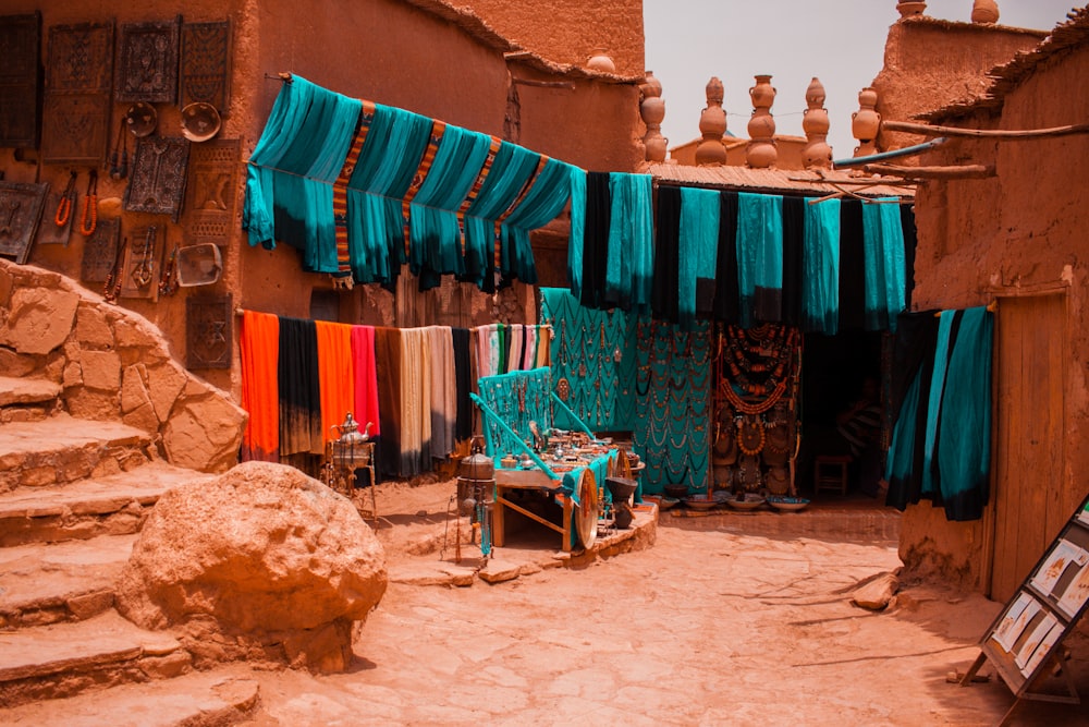 Des textiles de couleurs variées accrochés à côté de bâtiments en béton