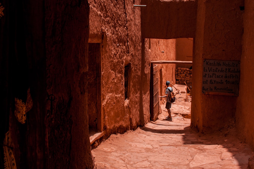 a person walking down a narrow alley way