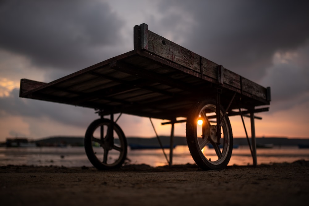 brown and black utility trailer on ground during sunset