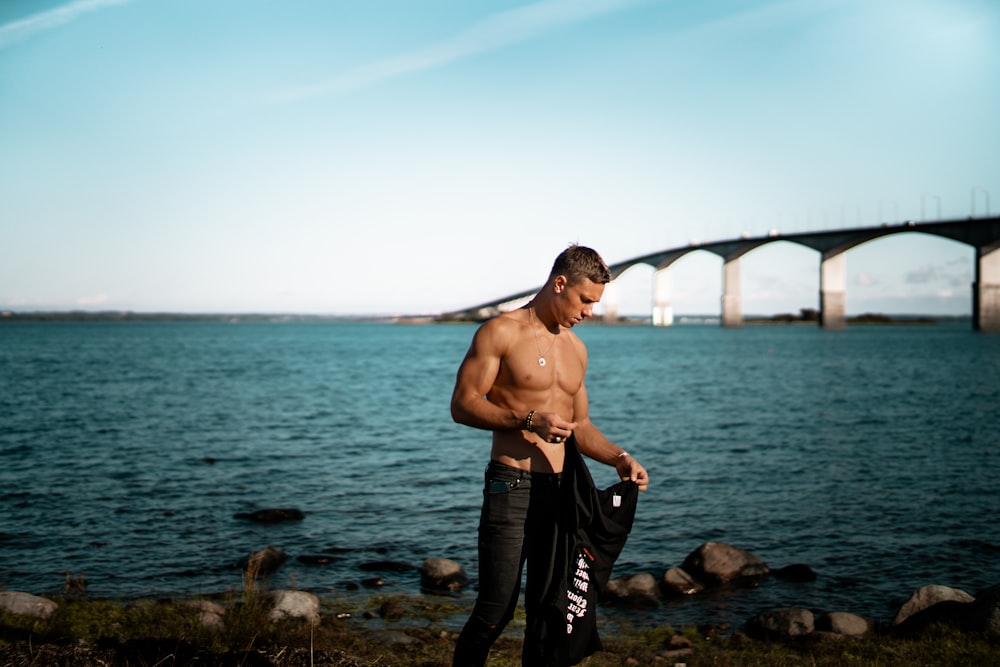 man standing near the shore in shallow photo