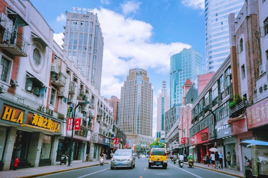 vehicle on road between buildings at daytime photo in Hongkou China