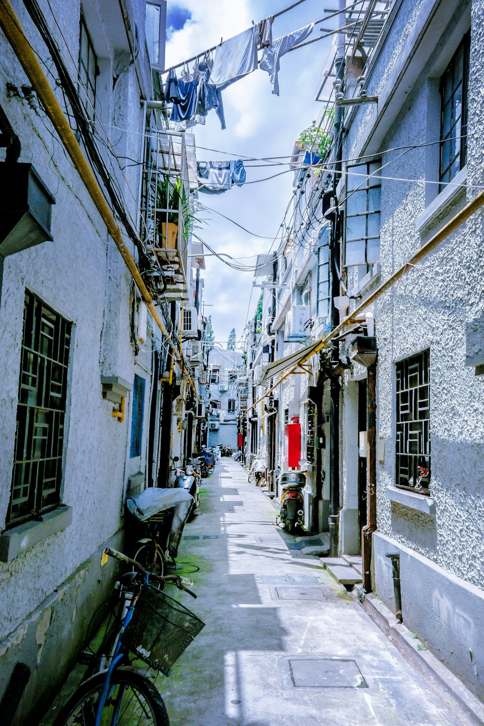 A bicycle parked in a narrow lane between old buildings in Shanghai's French Concession