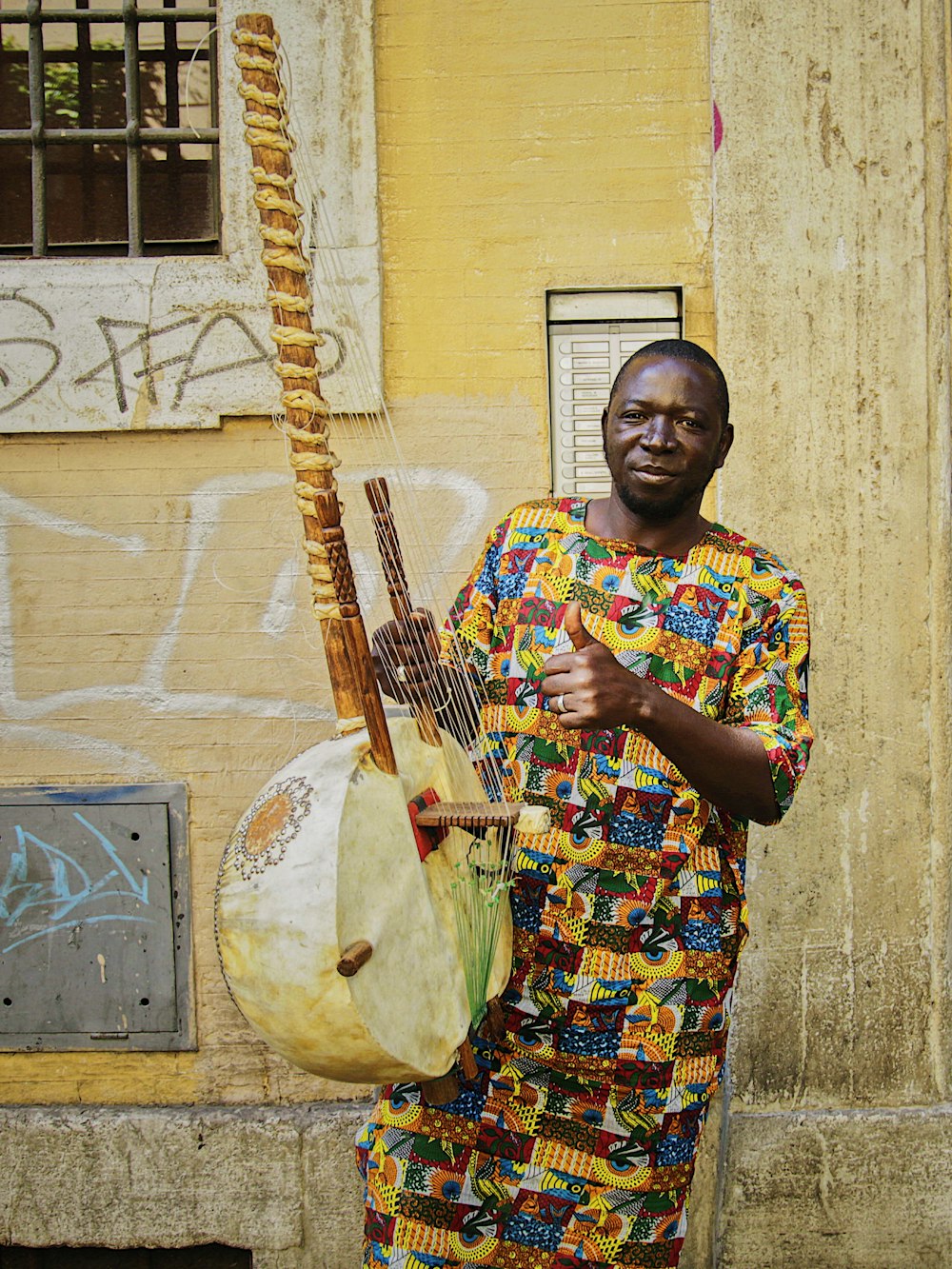 man playing string instrument near wall
