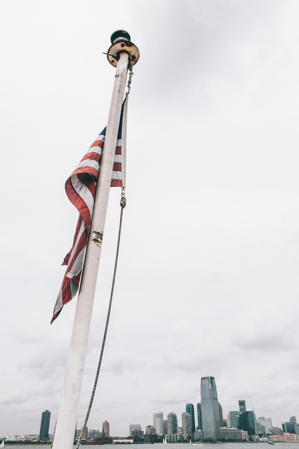 flag of US raised on white metal pole