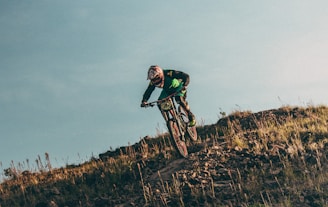 man riding bicycle downhill during daytime