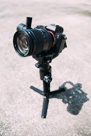 black DSLR camera on tripod stand