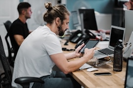 man holding turned-on iPad in front of turned-off MacBook Air