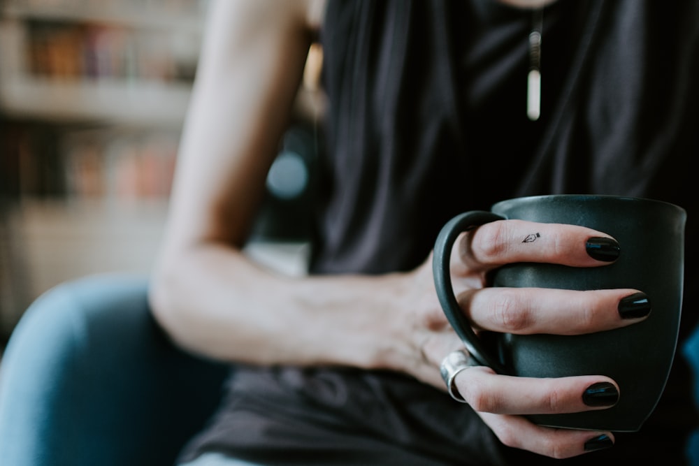 person holding green ceramic mug