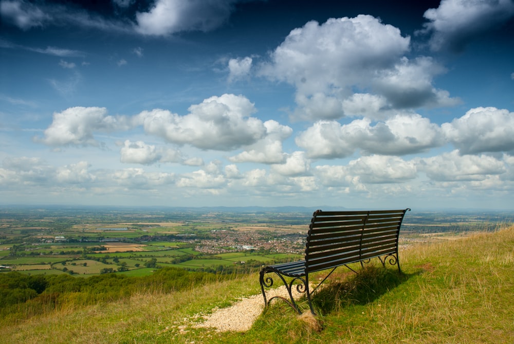 black bench on hill full of grasses