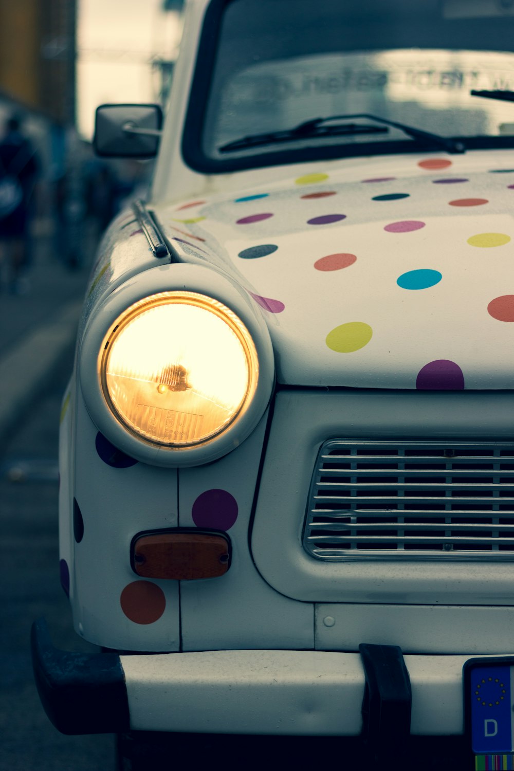 white and multicolored polka-dot vehicle with turned on headlight