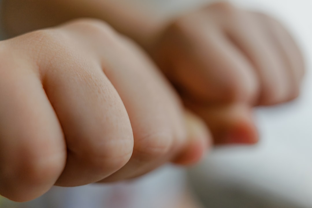 persons hand on white textile