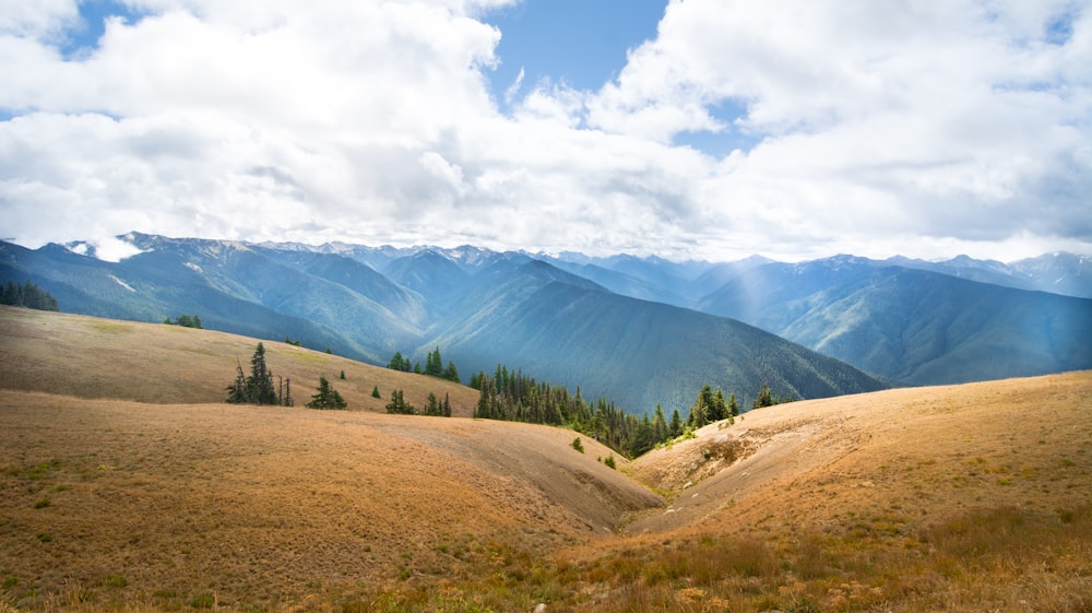 montaña verde y marrón bajo el cielo nublado