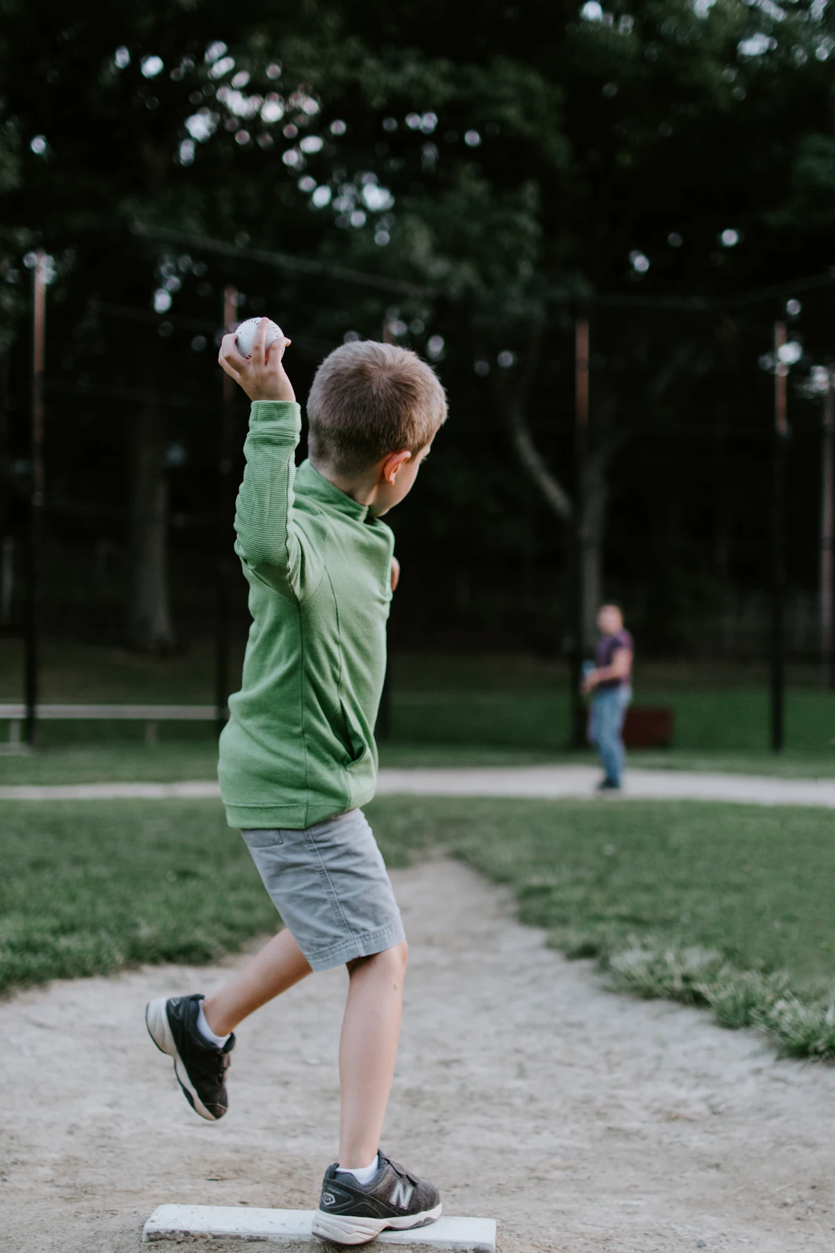 A young boy winding up to throw a baseball