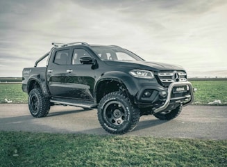 A rugged black pickup truck ready for work, parked on a gravel lot.