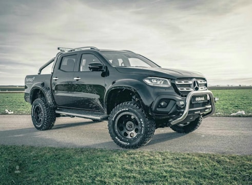 A rugged black pickup truck ready for work, parked on a gravel lot.