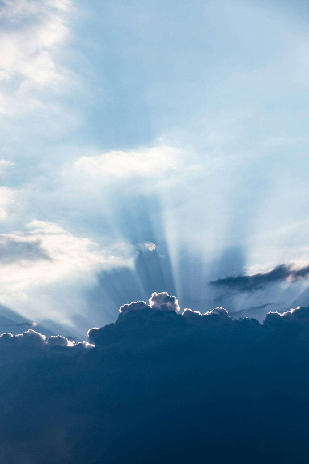 sun rays above silhouette of clouds