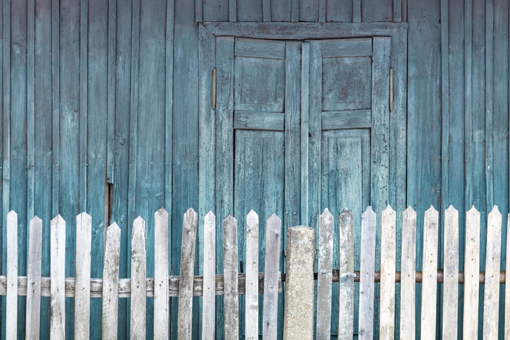 white and beige wooden fence beside wooden shed during daytime