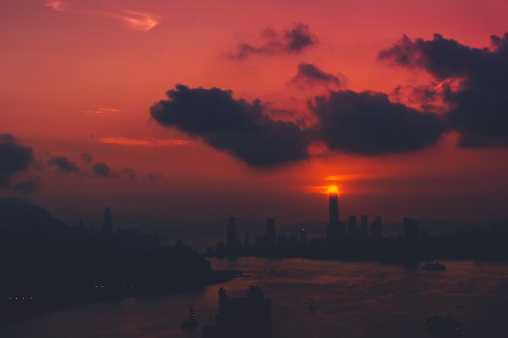 silhouette of buildings near sea at golden hour