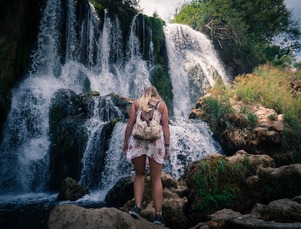 woman standing near waterfalls