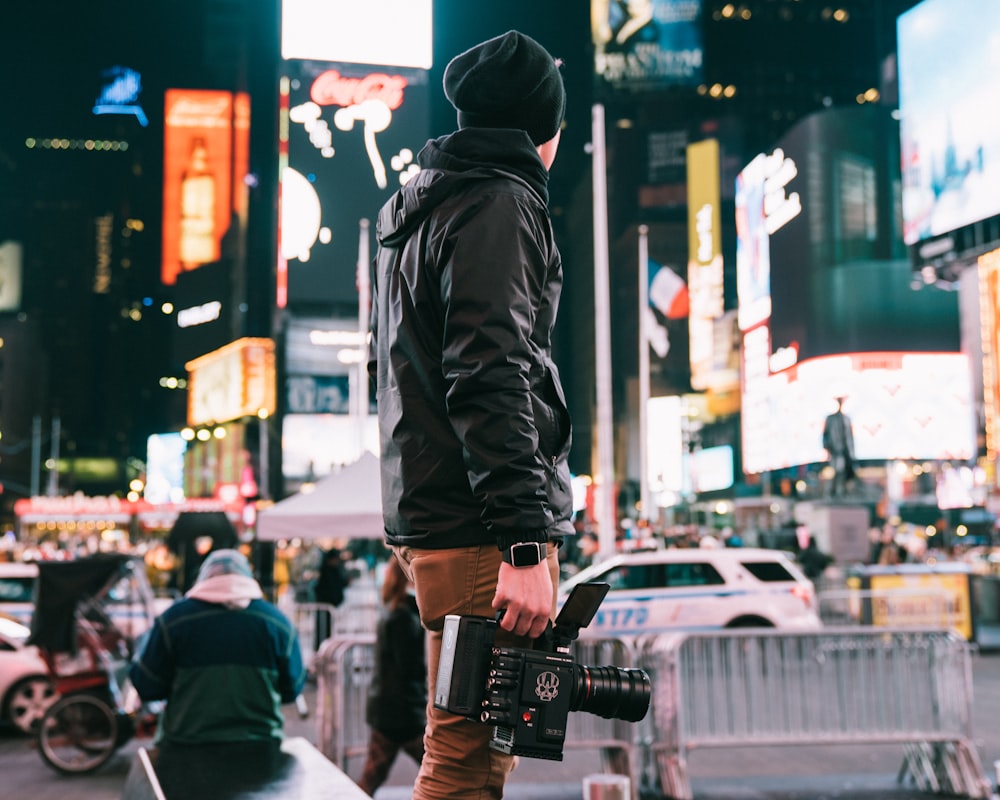 man holding camera looking at signage