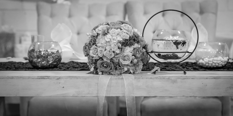 A beautifully arranged floral centerpiece on a polished wooden table, showcasing delicate craftsmanship.