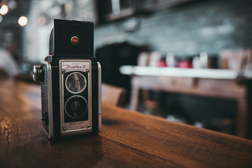 black and silver camera on brown wooden table