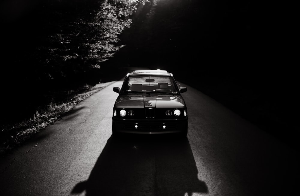 grayscale photo of vehicle on road