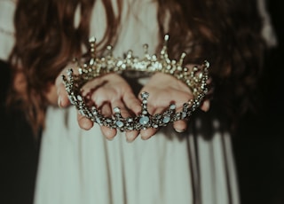 woman holding silver-colored crown
