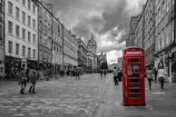 The iconic red telephone booths lining a bustling London street near historic buildings.