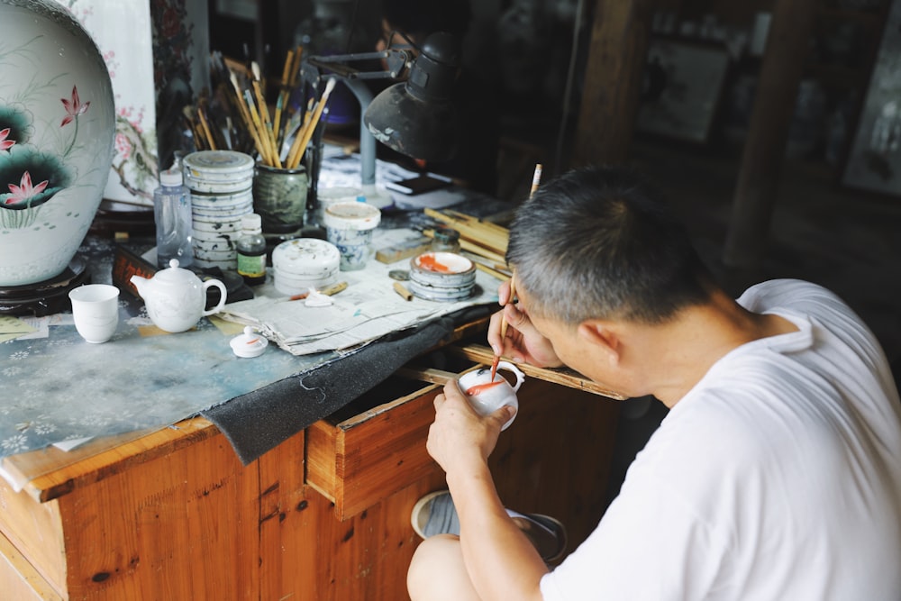 man painting ceramic mug