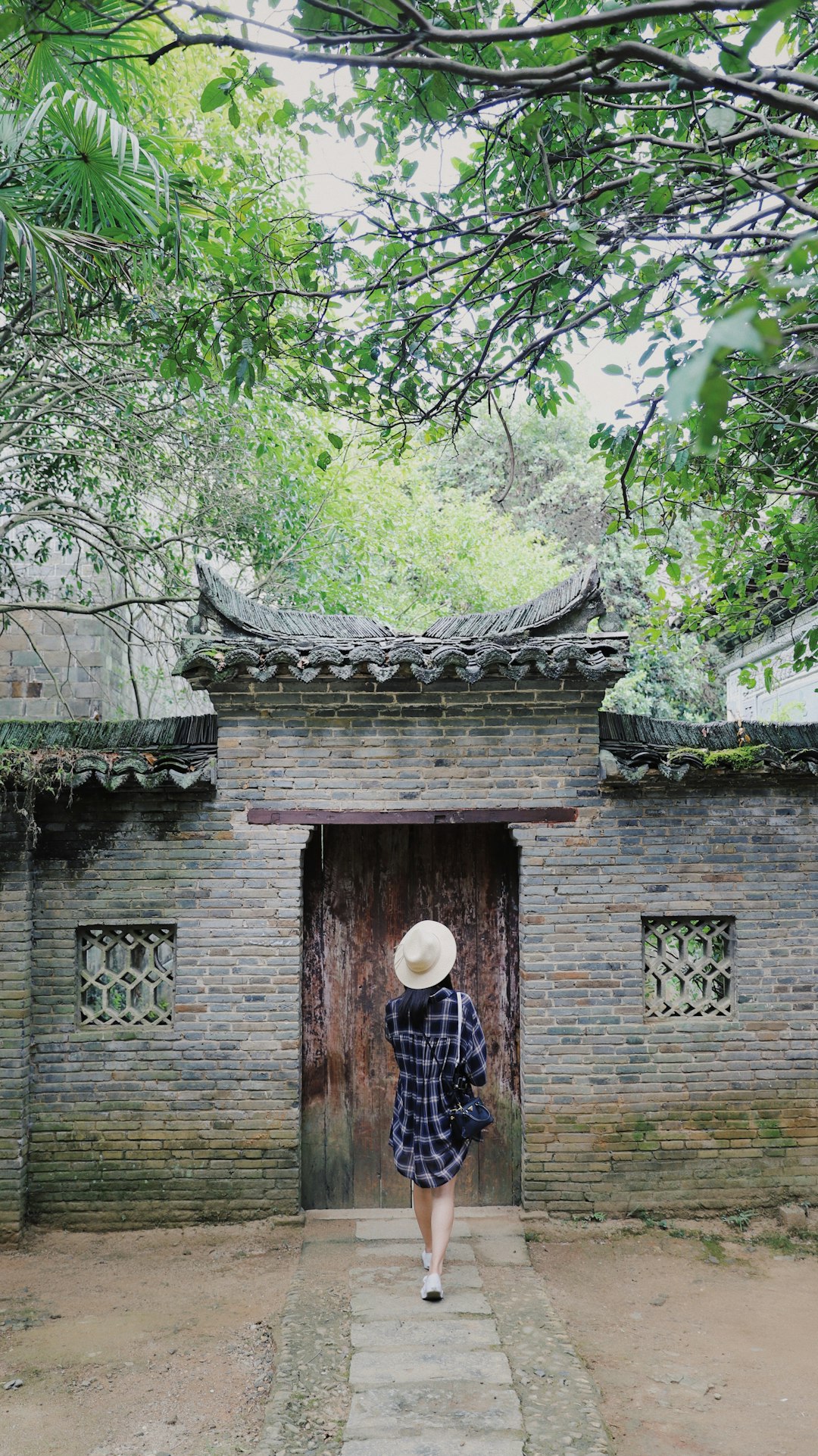 woman in black shirt standing in front of brown door