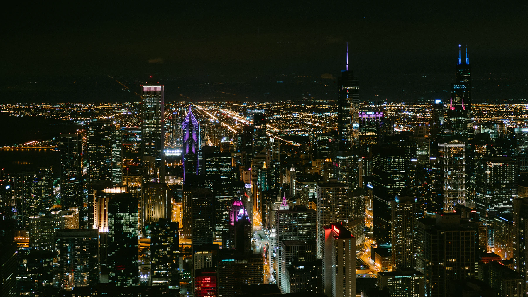 Aerial view of a city grid lit up after dark