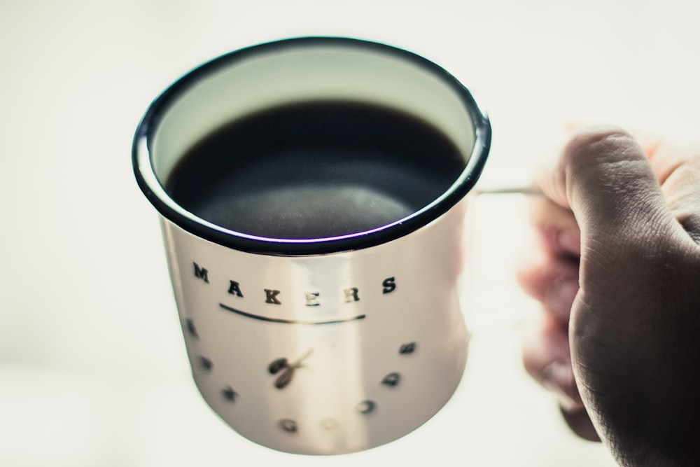 person holding white cup