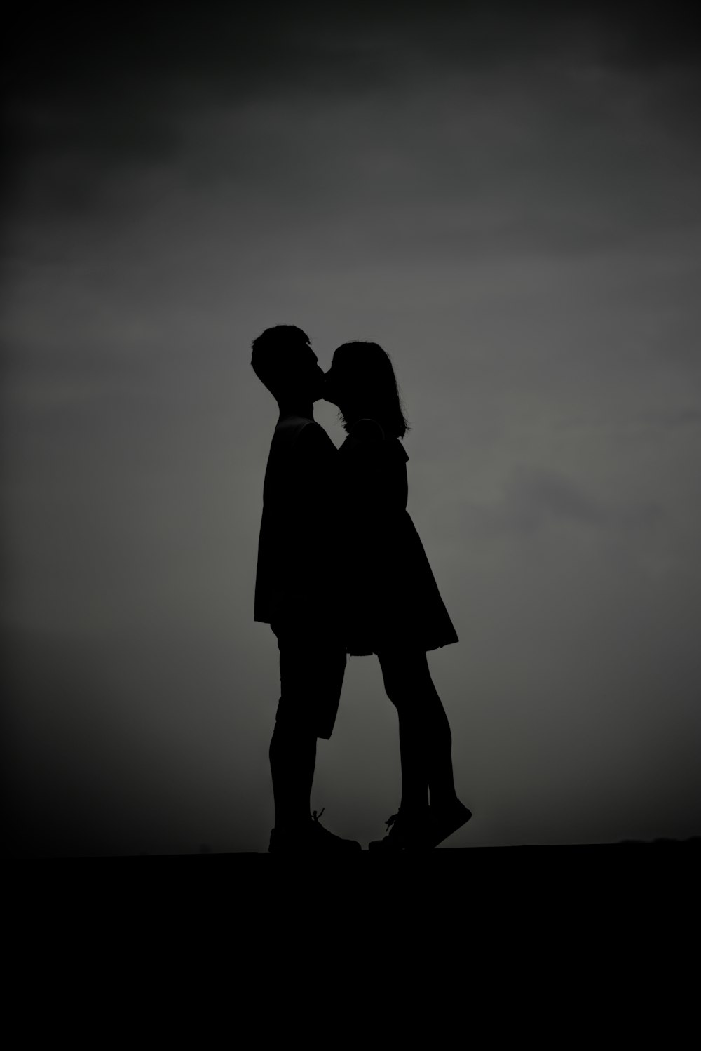 Foto da silhueta do homem e da mulher se beijando